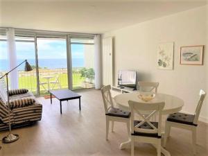 een woonkamer met een tafel en stoelen met uitzicht bij Appartement Quiberon, 2 pièces, 4 personnes - FR-1-478-147 in Quiberon