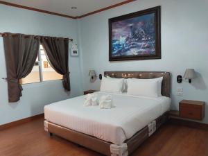 a bedroom with a bed with two stuffed animals on it at Tong Chang Resort in Chumphon