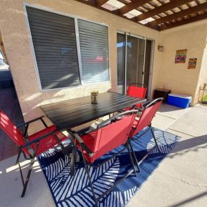 a picnic table and two red chairs on a patio at New beautifully remodeled home in Las Vegas in Las Vegas