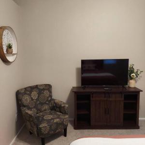 ein Wohnzimmer mit einem Stuhl und einem TV in der Unterkunft New beautifully remodeled home in Las Vegas in Las Vegas