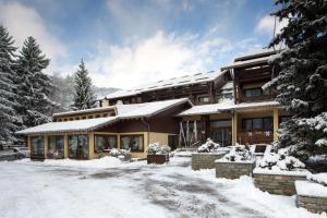 ein Haus mit Schnee auf dem Boden davor in der Unterkunft Palace Hotel Wellness & Beauty in Bormio