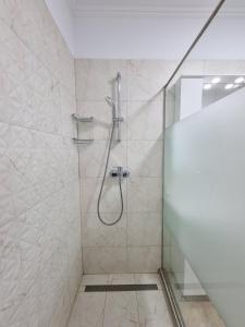 a bathroom with a shower with a glass door at Faleza Nord apartament de lux nou pe malul marii in Constanţa