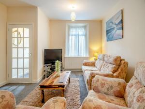 a living room with two couches and a tv at Lime House in Gorseinon