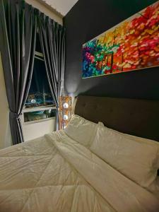 a bedroom with a bed and a painting on the wall at Novo 8 2-Bedrooms Condo Extreme City View Suite in Melaka