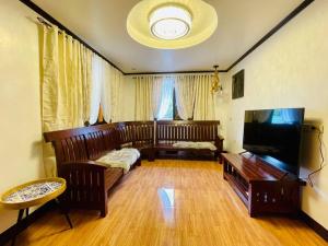 Μια τηλεόραση ή/και κέντρο ψυχαγωγίας στο La Famille Guesthouse Pundaquit Mountain view and walking distance to beach