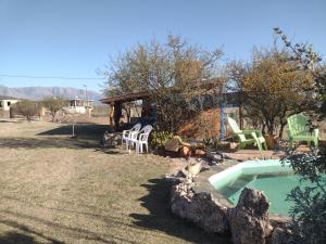 un patio trasero con piscina y sillas y una casa en La Pirca en Nono