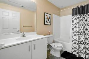 a bathroom with a sink and a toilet and a shower curtain at Luxury 2BR/2BA!5Min to Disney! Angelstadium! HondaCenter. in Anaheim