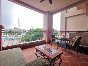 einen Balkon mit Tischen und Stühlen und Flussblick in der Unterkunft Casa del Rio Residences in Malakka