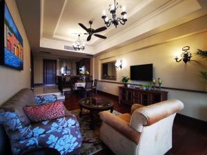 ein Wohnzimmer mit einem Sofa und einem TV in der Unterkunft Casa del Rio Residences in Malakka