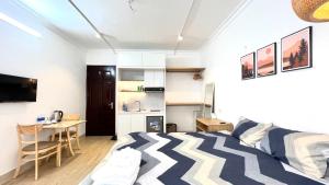 Il comprend une chambre avec un lit, un bureau et une cuisine. dans l'établissement The Hive Homestay, à Hanoï