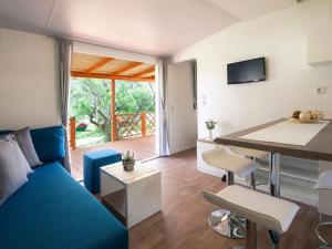 a living room with a blue couch and a table at Mobile Home in Starigrad by Pebble Beach in Starigrad-Paklenica
