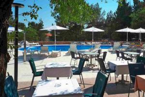 an outdoor patio with tables and chairs and a pool at Caravan park Paklenica Starigrad Paklenica - CDN05014-MYA in Starigrad-Paklenica