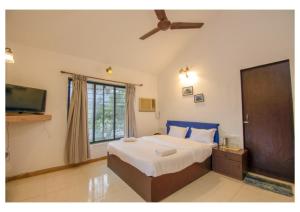 um quarto com uma cama grande e uma televisão em Vinayak 5Bhk Villa Lonavala em Lonavala