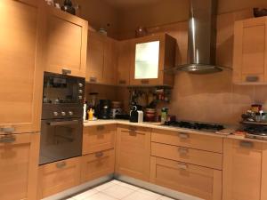 Una cocina con gabinetes de madera y un horno de estufa. en villa Gaby-chambres, en Menton