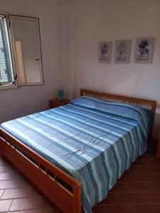 Dormitorio con cama con edredón azul y espejo en La casa di Giorgia a Capo Vaticano, en Capo Vaticano