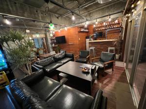 a living room with leather couches and a table at HOSTEL OE in Yoshinogawa
