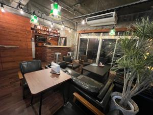 a dining room with a table and chairs and a plant at HOSTEL OE in Yoshinogawa