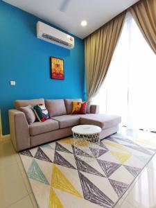 uma sala de estar com um sofá e uma parede azul em D'Pristine by Iconic Bliss em Nusajaya