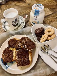 a tray with a plate of cake and a bowl of cookies at B&B Camelia in Città di Castello