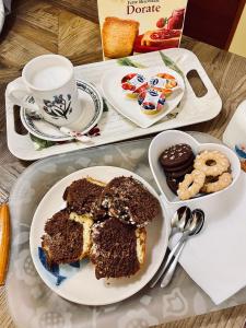 una mesa con un plato de pastel y un tazón de galletas en B&B Camelia, en Città di Castello
