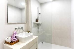 ein weißes Bad mit einem Waschbecken und einer Dusche in der Unterkunft 4Guests BeachFront SK HuaHin by น้องมังคุด in Hua Hin