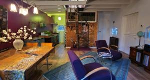 ein Wohnzimmer mit einem Holztisch und lila Stühlen in der Unterkunft Wonderland in Pieterburen