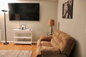 uma sala de estar com um sofá e uma televisão em The Little Amazon em Montgomery