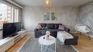 a living room with a couch and a tv at Bellarova Apartments I in Rovaniemi