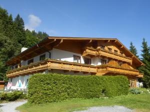 a large wooden house with a hedge in front of it at Kurcamping Erlengrund in Bad Gastein