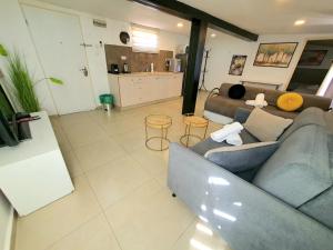 ein Wohnzimmer mit einem Sofa und einer Küche in der Unterkunft Barak Royal Suites 20 sea view - ג'קוזי בחצר ומרפסות עם נוף לים in Eilat