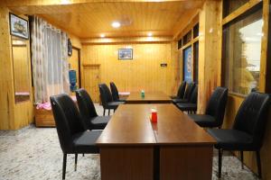 a conference room with wooden walls and tables and chairs at Matina Regency in Gangtok