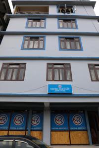 a building with a sign on the front of it at Matina Regency in Gangtok