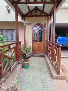 a house with a wooden door and a porch at Antsirabe Hotel in Antsirabe