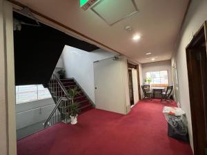 a hallway with a staircase with a red carpet at HOSTEL OE in Yoshinogawa