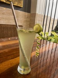 a drink with a lime on a wooden table at Bliss Rooms in Alibaug