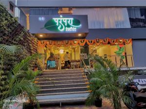 a man standing in front of a building with stairs at Bliss Rooms in Alibaug