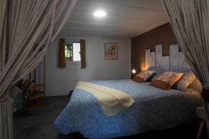 Un dormitorio con una cama grande en una habitación. en Le Jaboticaba, en Salazie 6 fotos más