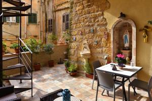 a patio with a table and some potted plants at L’elegante dépendance del Barone Francesco Sala in Agrigento