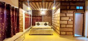 ein Schlafzimmer mit einem Bett in einer Ziegelwand in der Unterkunft Gopal Home Stay & Guest House in Jodhpur