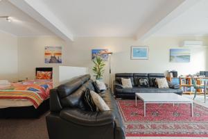 Black Dolphin Waterfront Apartment في سانريمو: غرفة معيشة مع أريكة وسرير