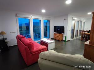 sala de estar con sofá rojo y TV en Casa con vistas a la Sierra de Guadarrama en Guadarrama