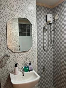 a bathroom with a sink and a shower with a mirror at Palompon Sugar's Inn in Palompon