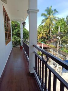 a balcony of a house with a view of trees at PRAKRITI HOMESTAY Fortkochi Air Conditioned Rooms in Cochin