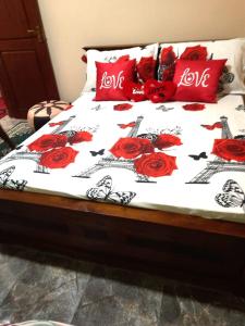 uma cama com rosas vermelhas e as palavras amor sobre ela em Happy Nest em Talagala