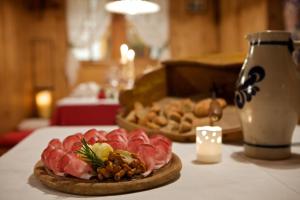 een tafel met een bord eten op een tafel bij Hotel B&B Pardeller in Nova Levante