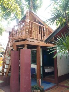 a house with a balcony on top of it at Garden House INChiangrai in Chiang Rai