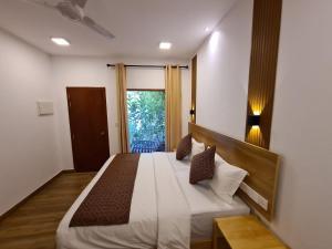 Un dormitorio con una cama grande y una ventana en Kihaa Holiday Home, en Finolhus