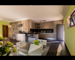 cocina grande con mesa de cristal en una habitación en Modern Three Bedroom House en Figueiró