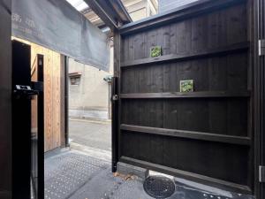 京都的住宿－至の宿-京都南 Traditional Machiya Guesthouse，木车库门,上面有两架架架子