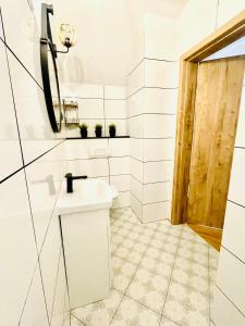 GÓRSKA CISZA - Apartamenty في سترونيش لونسكي: حمام أبيض مع حوض ومرآة